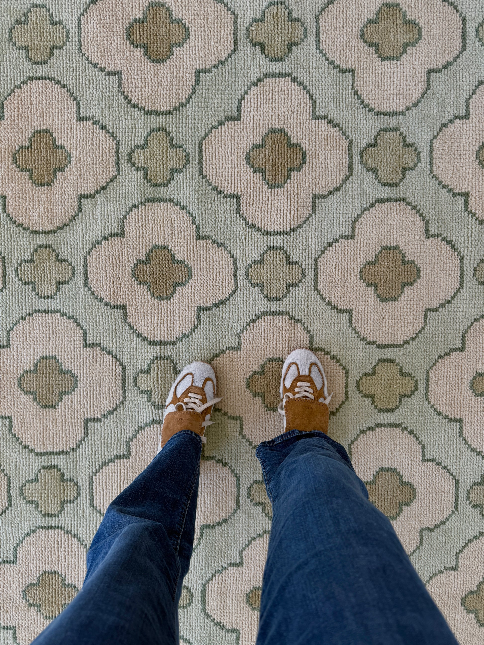 Patterned handknotted rug with geometric floral design on a light blue background