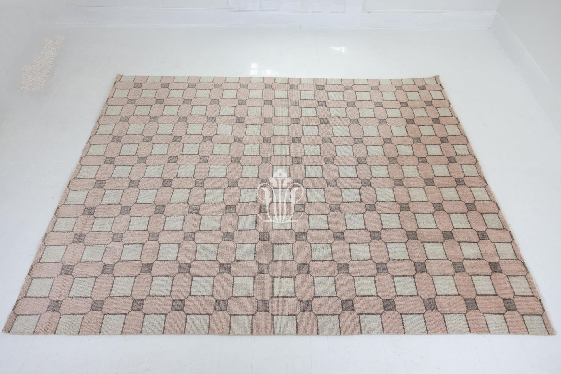 Checkered patterned rug with a central logo on a white background