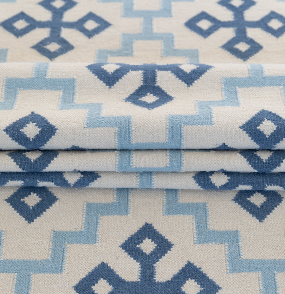 1. Close-up of Denim Cross flatweave rug featuring denim blue and sky blue geometric motifs