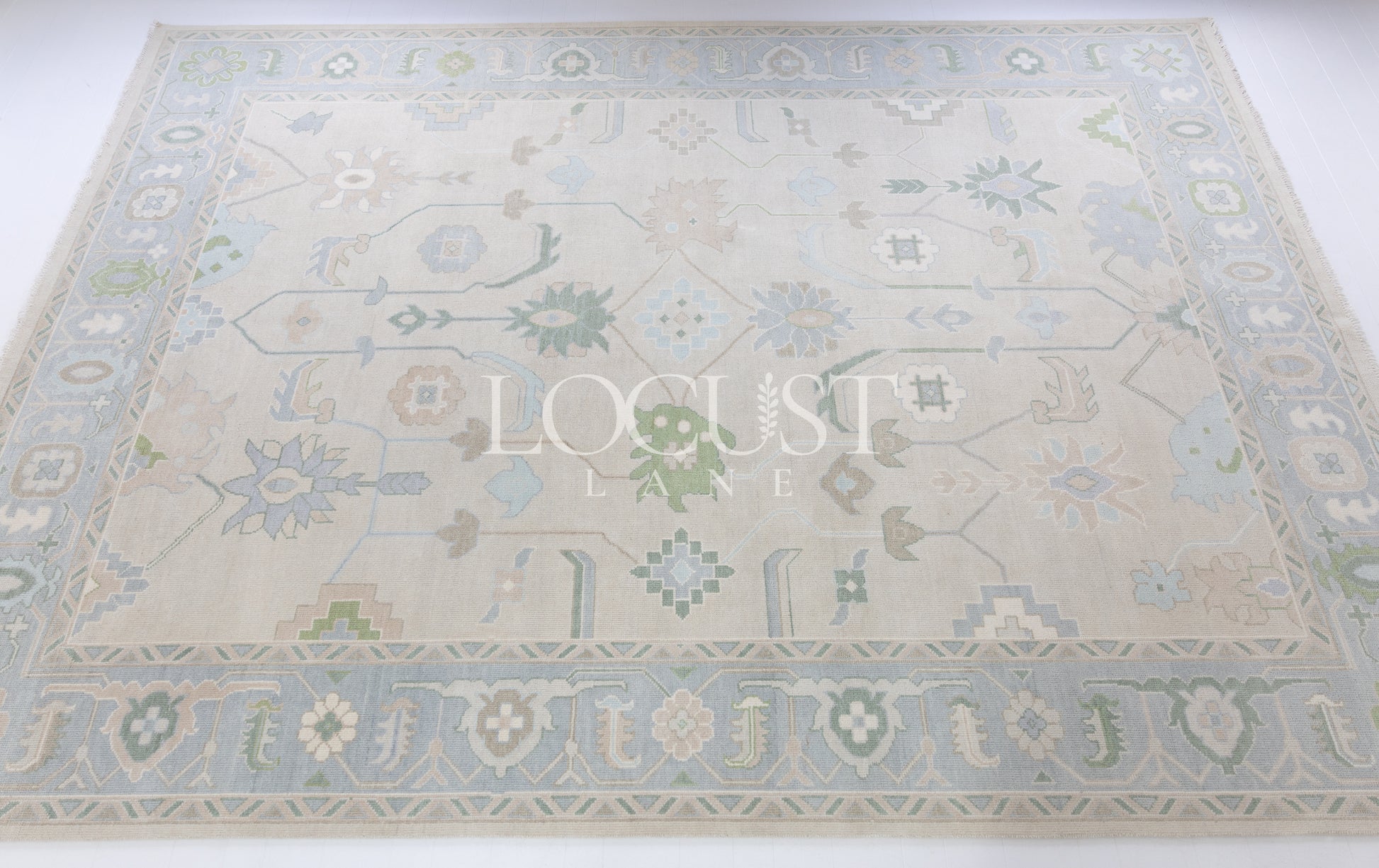 Fiona hand-knotted wool Oushak rug in ivory and faded blue from Locust Lane Rugs.