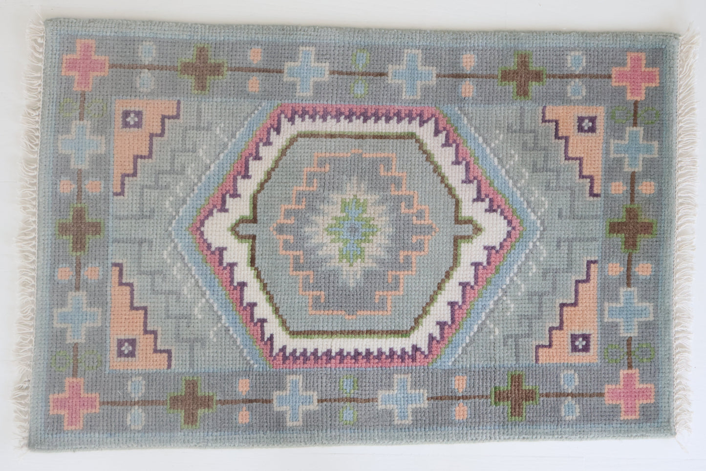 Hand-knotted wool rug featuring a geometric medallion design in soft sky blue, blush, olive, and lavender tones – Maisie Rug by Locust Lane Rugs