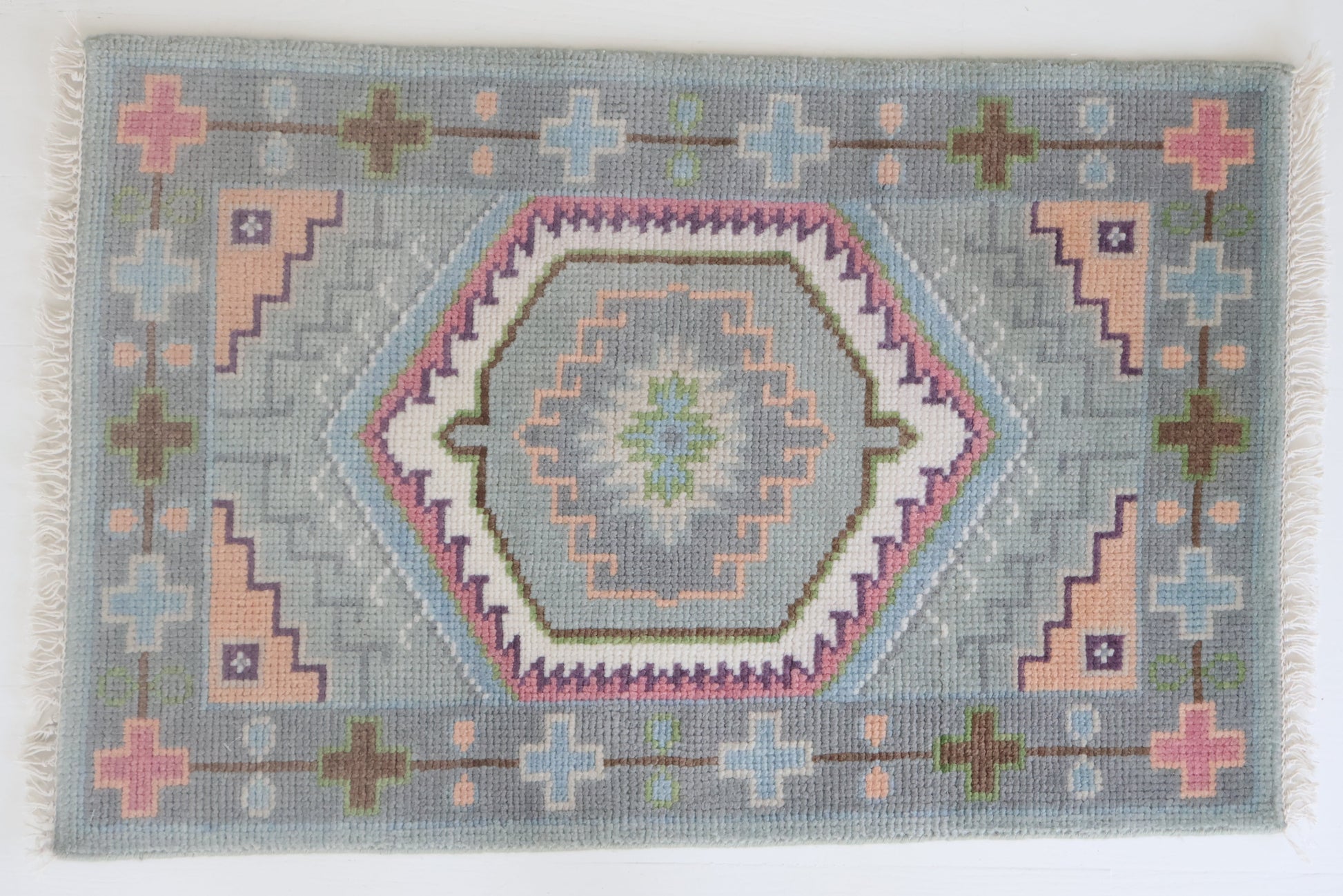 Hand-knotted wool rug featuring a geometric medallion design in soft sky blue, blush, olive, and lavender tones – Maisie Rug by Locust Lane Rugs