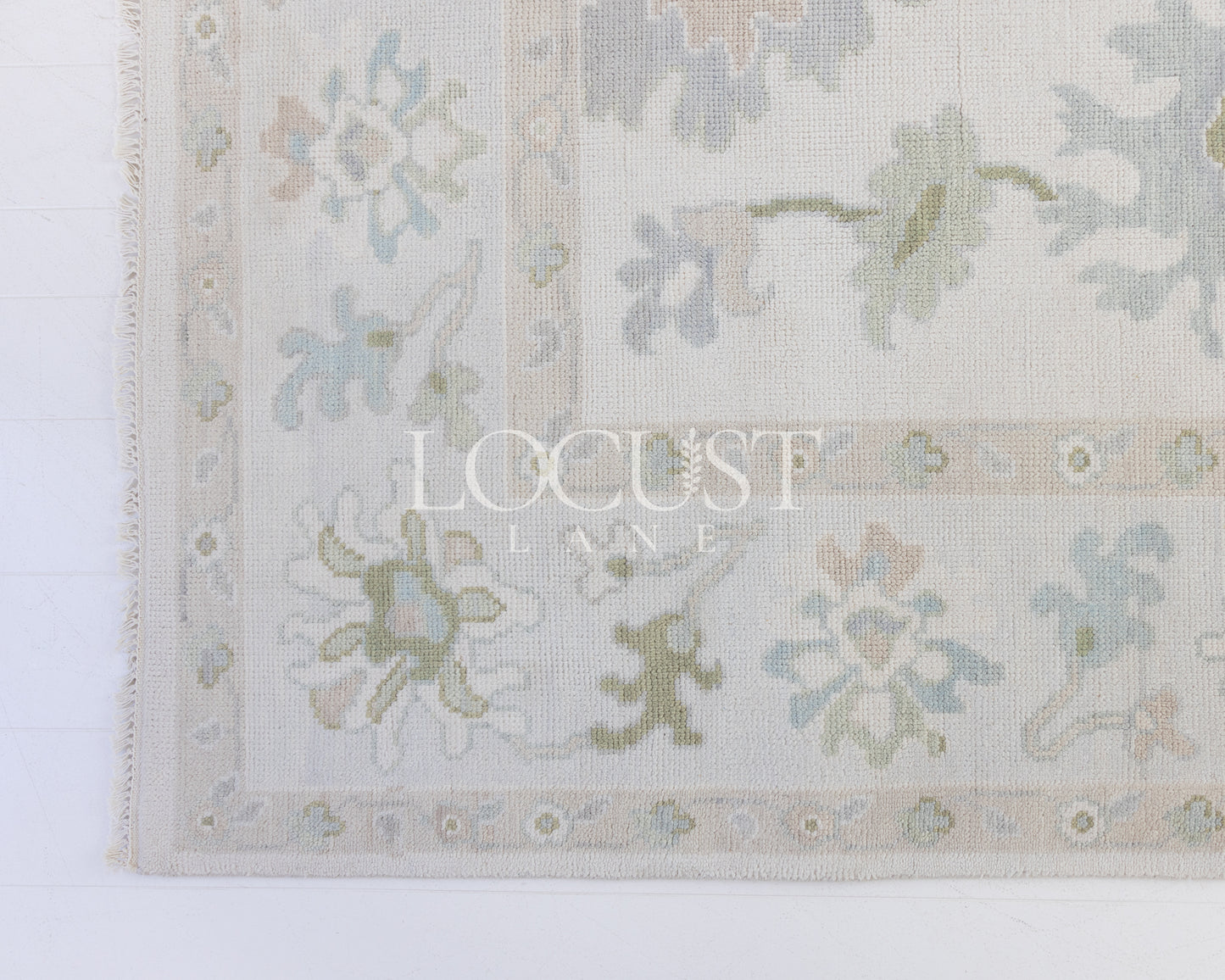 cream hand knotted rug with blues and greens