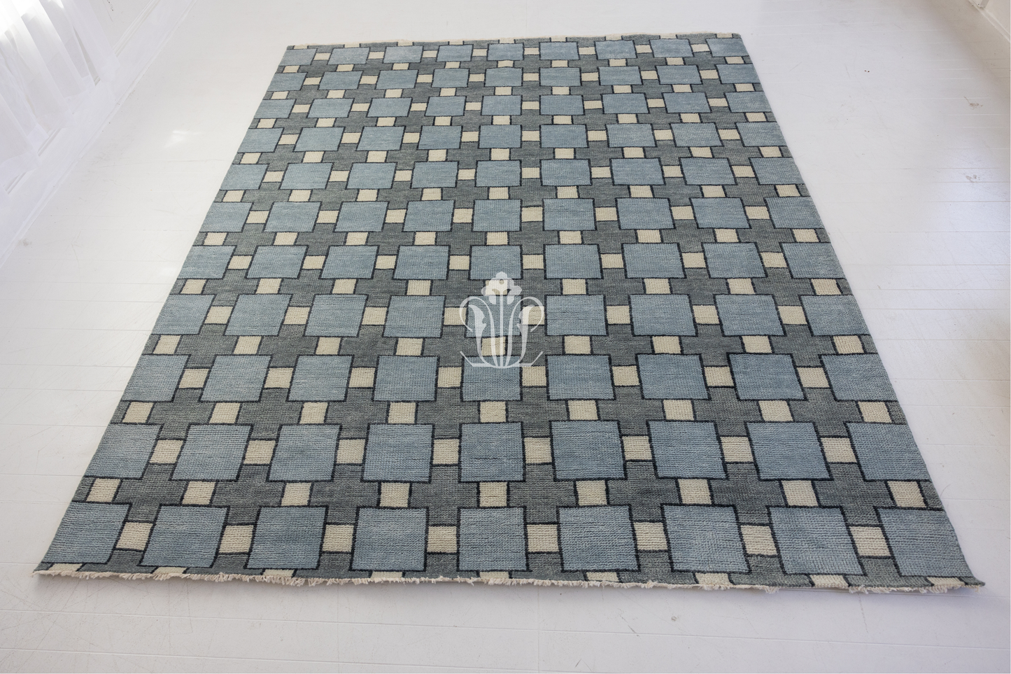 Blue and gray checkered rug with a logo on a white background