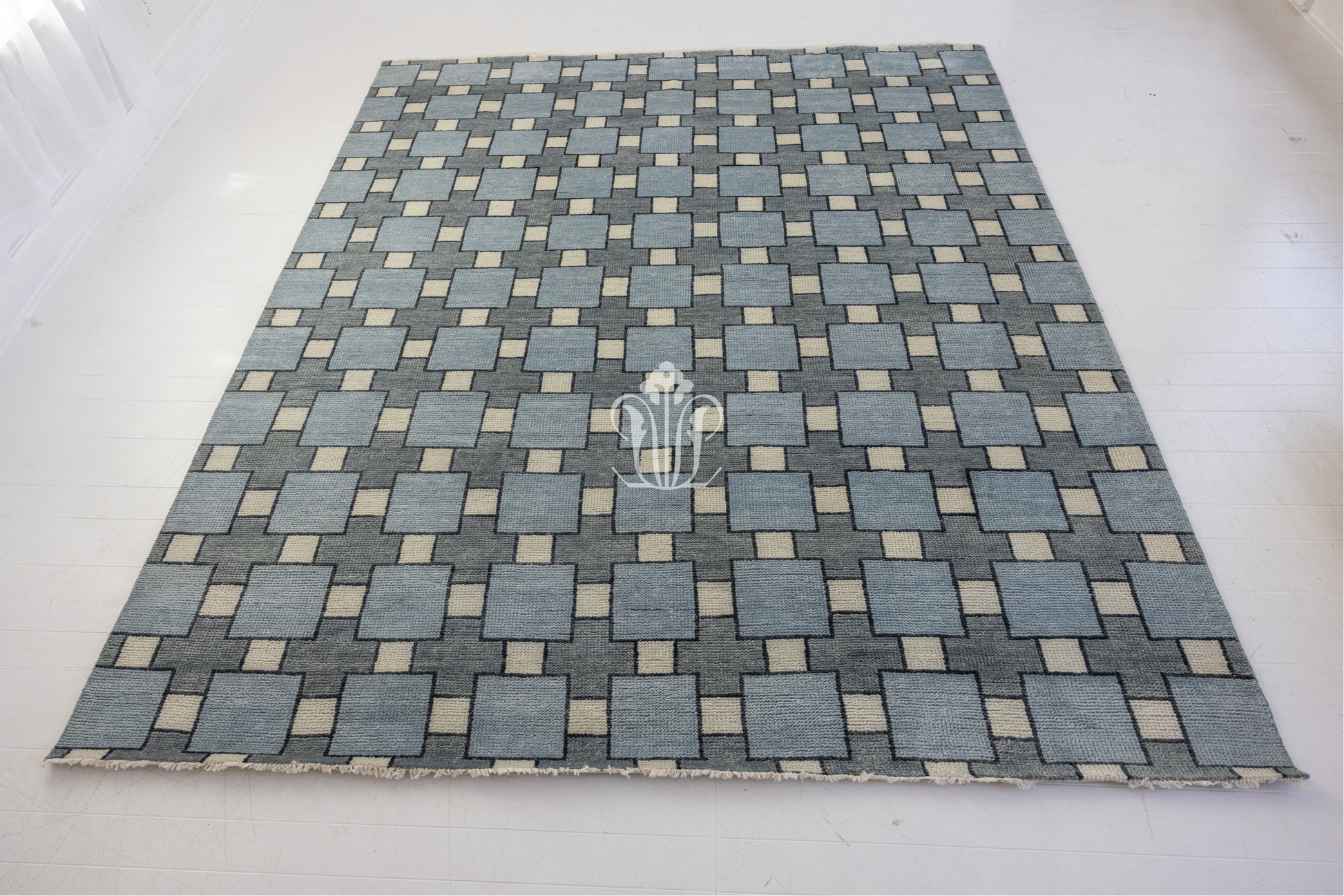 Blue and gray checkered rug with a logo on a white background