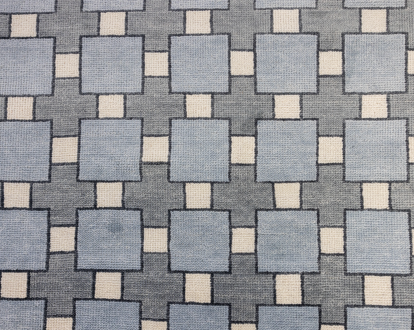 Patterned fabric with blue and beige squares on a gray background
