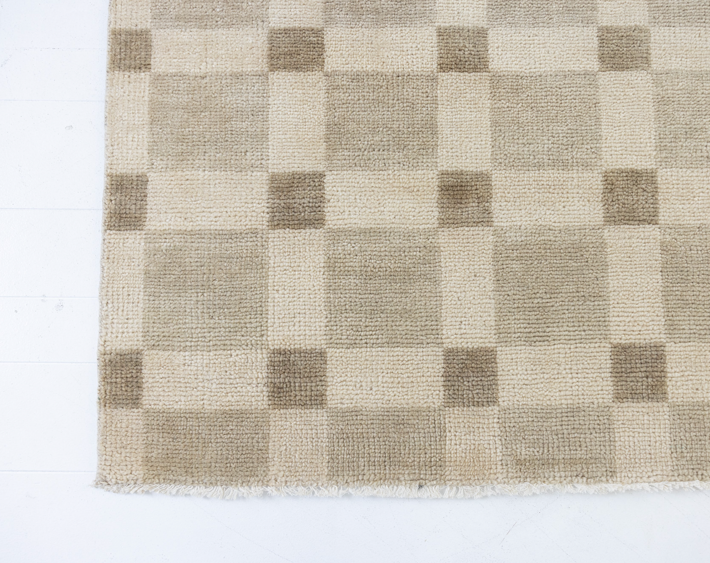 Checkered rug with brown and beige squares on a white background