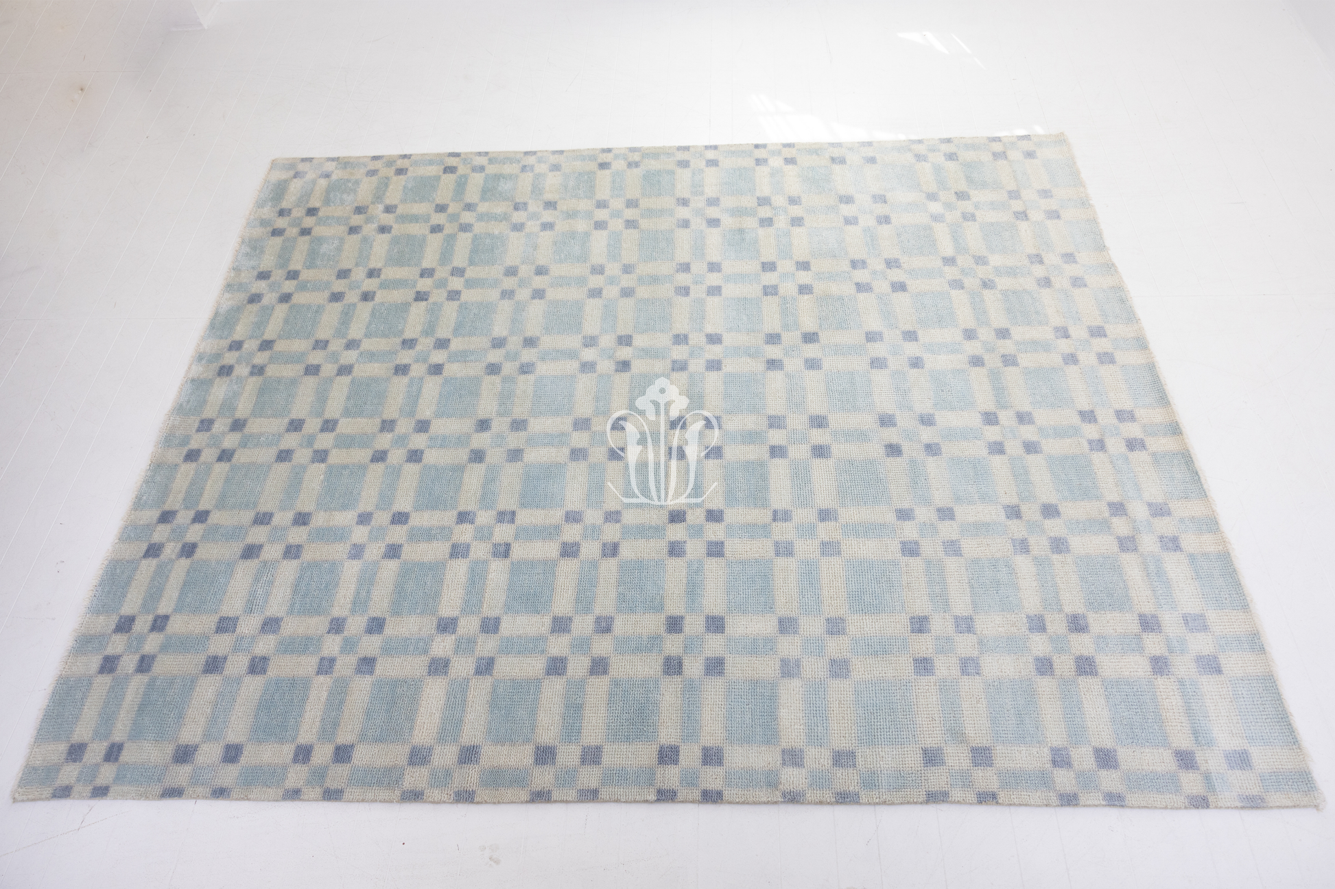 Checkered patterned rug with a logo on a white background