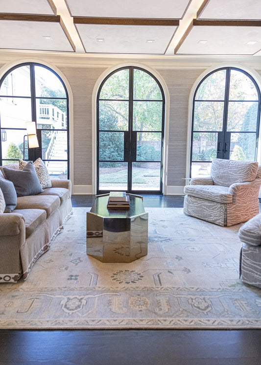 Bright living room featuring a handcrafted Modern Oushak wool rug in soft blue, ivory, and warm neutral tones.