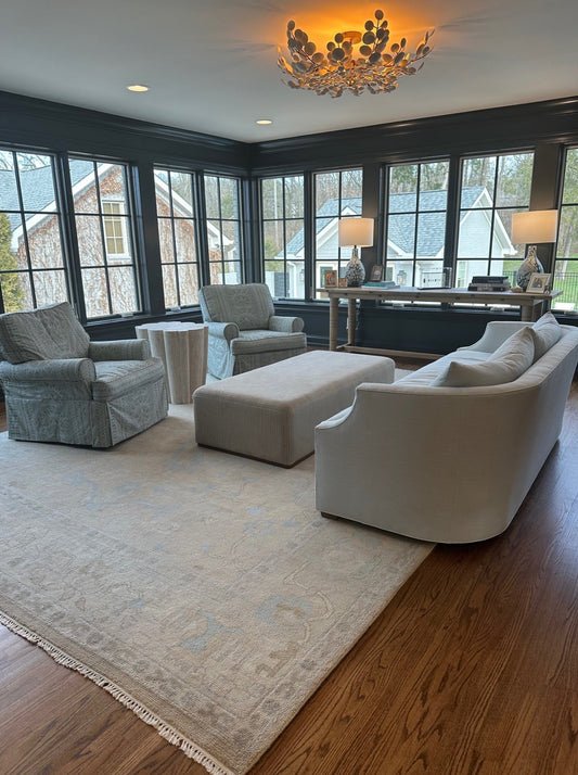 Elegant living room featuring a handcrafted Modern Oushak wool rug in soft ivory, warm beige, and subtle blue tones.