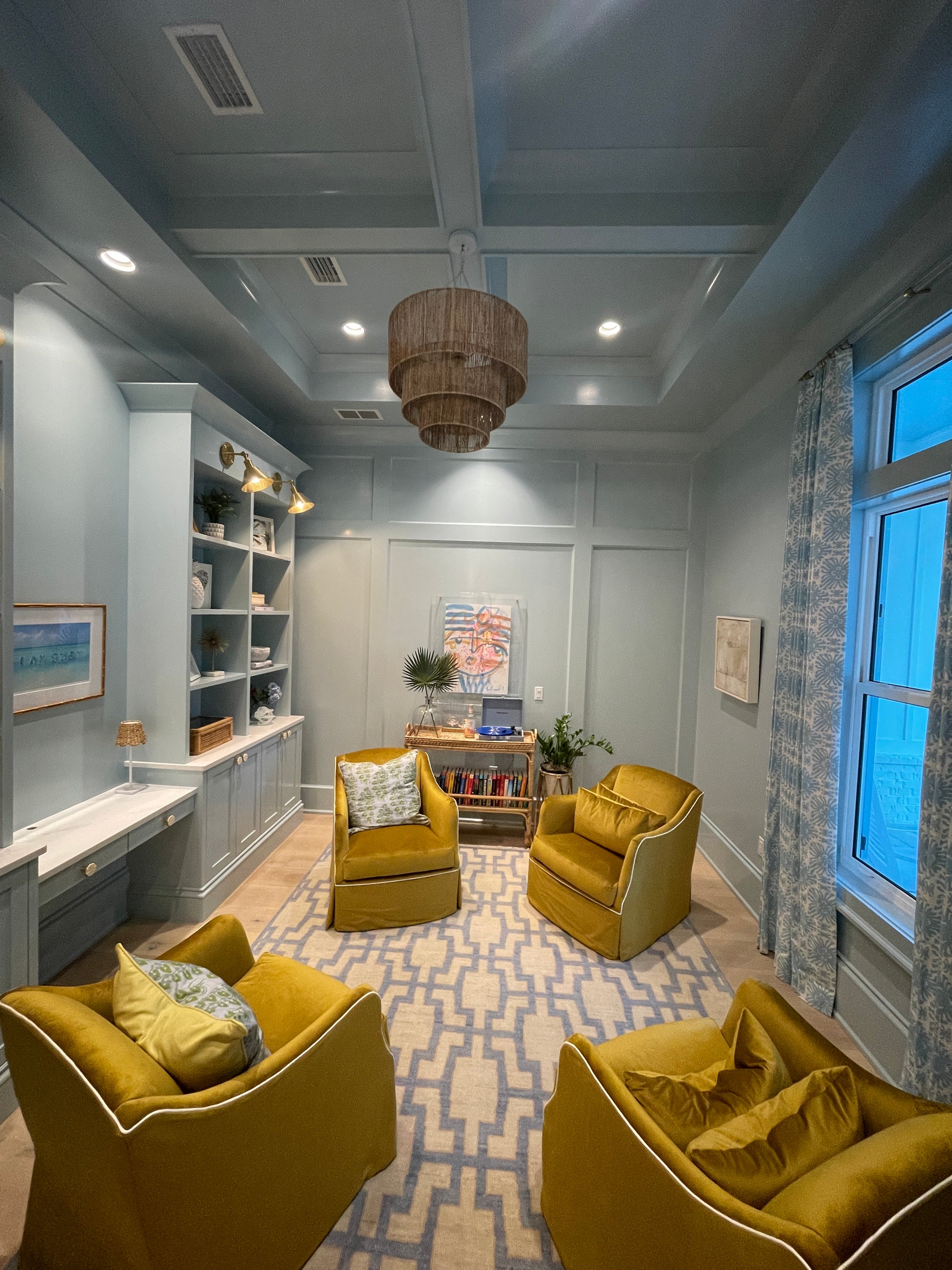 Della hand-knotted wool rug in blue, ivory, and chartreuse from Locust Lane Rugs. In a study.