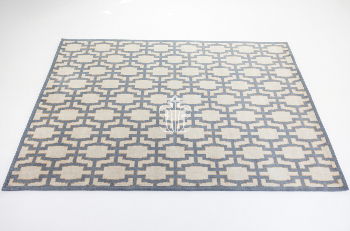 A rectangular area rug with a geometric lattice pattern in beige and slate blue, shown from a top-down perspective on a white background.
