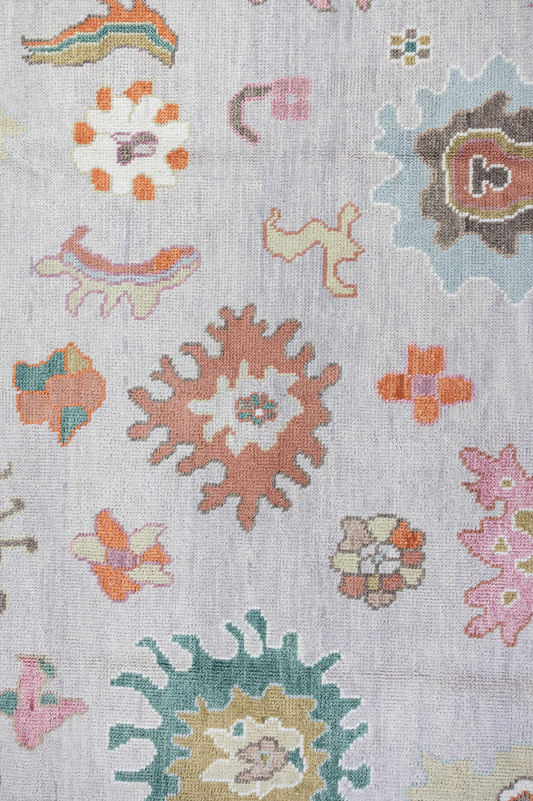 Close-up of a patterned rug with floral designs on a light background