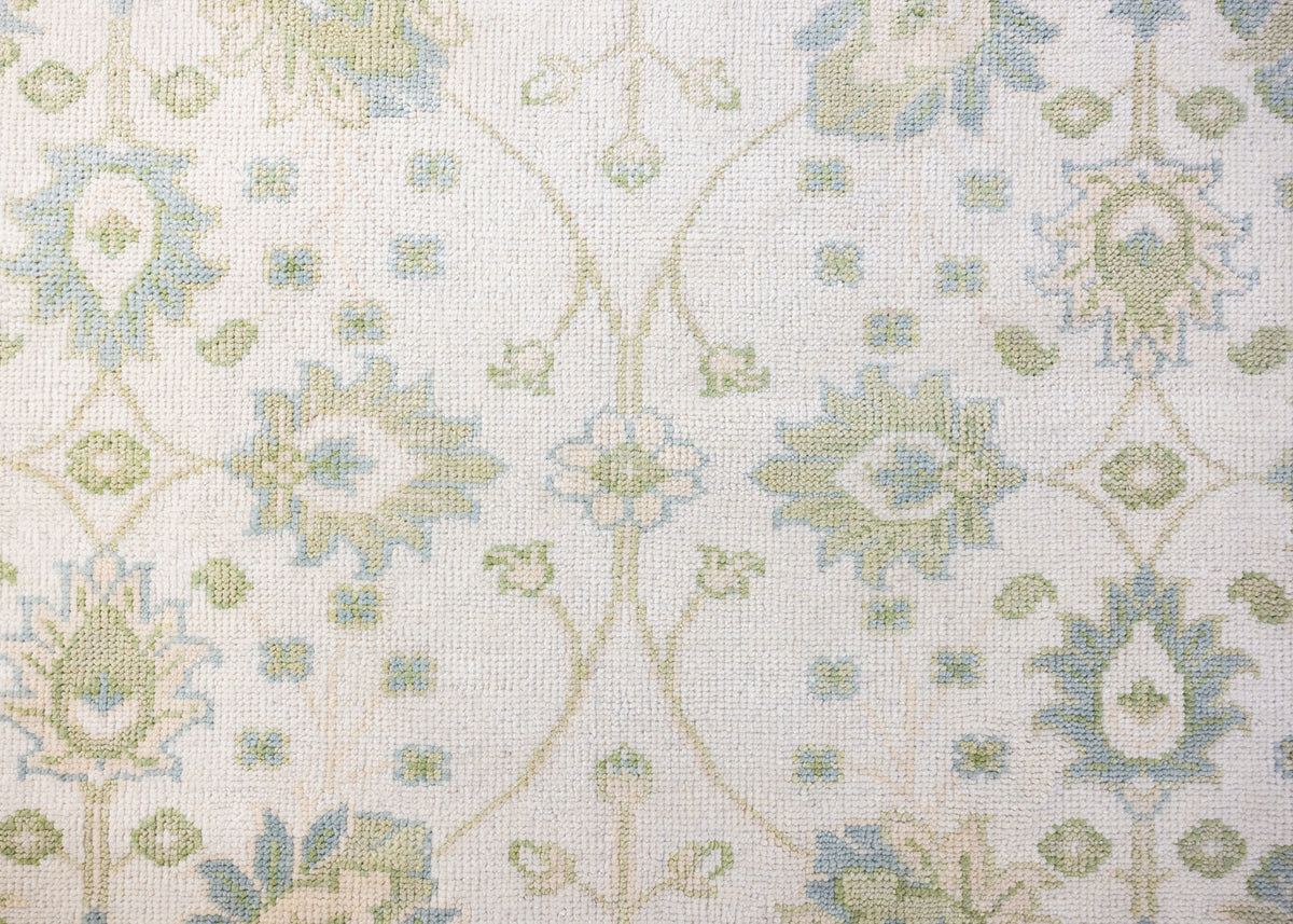 Essie hand-knotted wool Modern Oushak rug featuring a floral pattern in soft blue, sage green, and ivory.