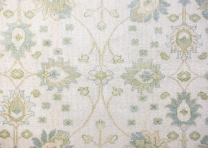 Essie hand-knotted wool Modern Oushak rug featuring a floral pattern in soft blue, sage green, and ivory.
