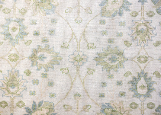 Essie hand-knotted wool Modern Oushak rug featuring a floral pattern in soft blue, sage green, and ivory.