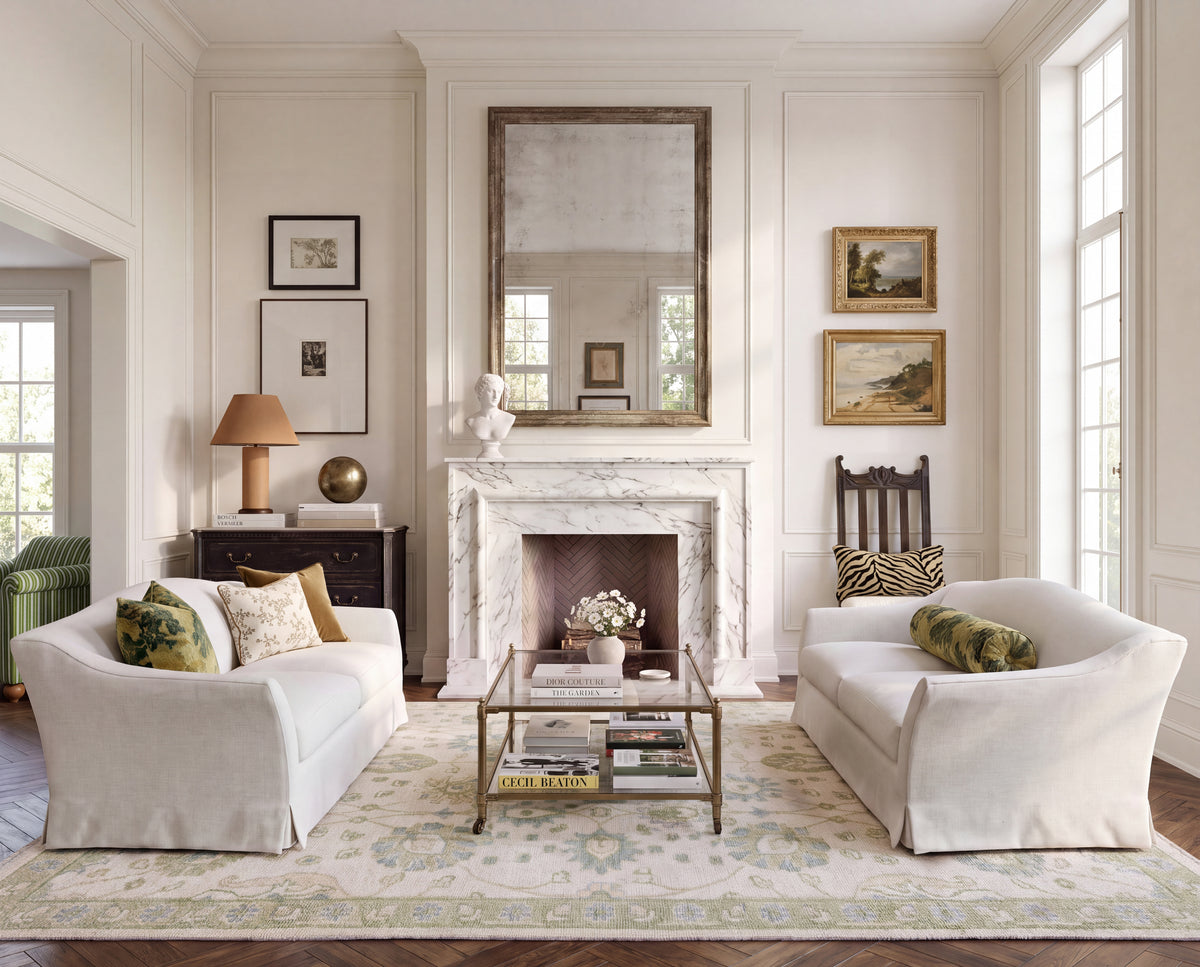 Essie blue and green Oushak area rug styled in a traditional living room with ivory sofas and classic furnishings.