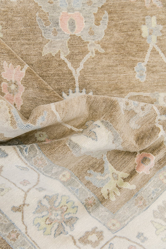 Gigi luxury hand-knotted wool Oushak rug in warm beige, ivory, and soft pastel tones