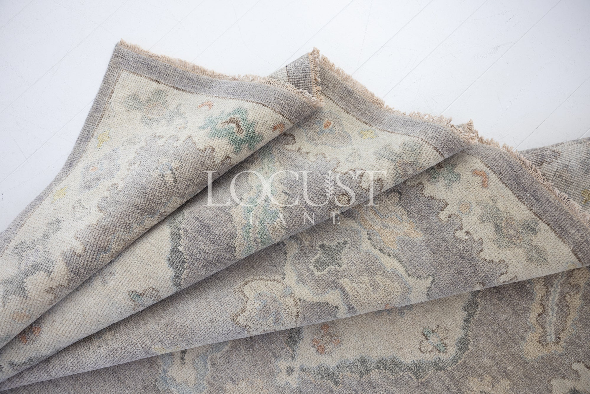 purplish grey hand knotted rug with pastel 