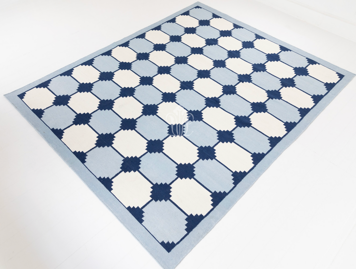 Handwoven navy and white flatweave area rug featuring a bold geometric design