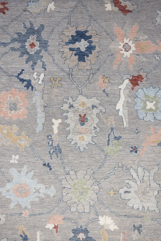 Peggy hand-knotted wool Oushak rug with gray background and colorful blue, pink, and coral floral motifs