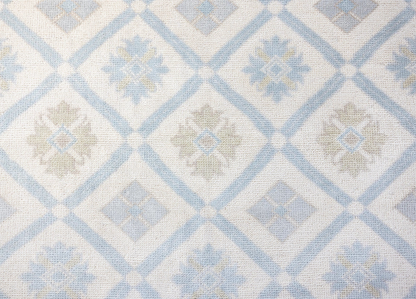 Pippa hand-knotted wool Modern Oushak rug featuring a powder blue and ivory diamond pattern with delicate floral motifs and soft beige accents.