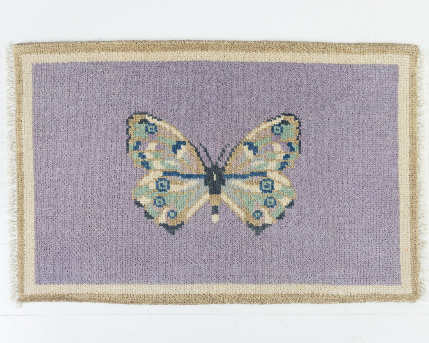 Hand-knotted wool rug featuring a butterfly motif on a lavender background with ivory and taupe border – Purple Butterfly Mini Rug by Locust Lane Rugs
