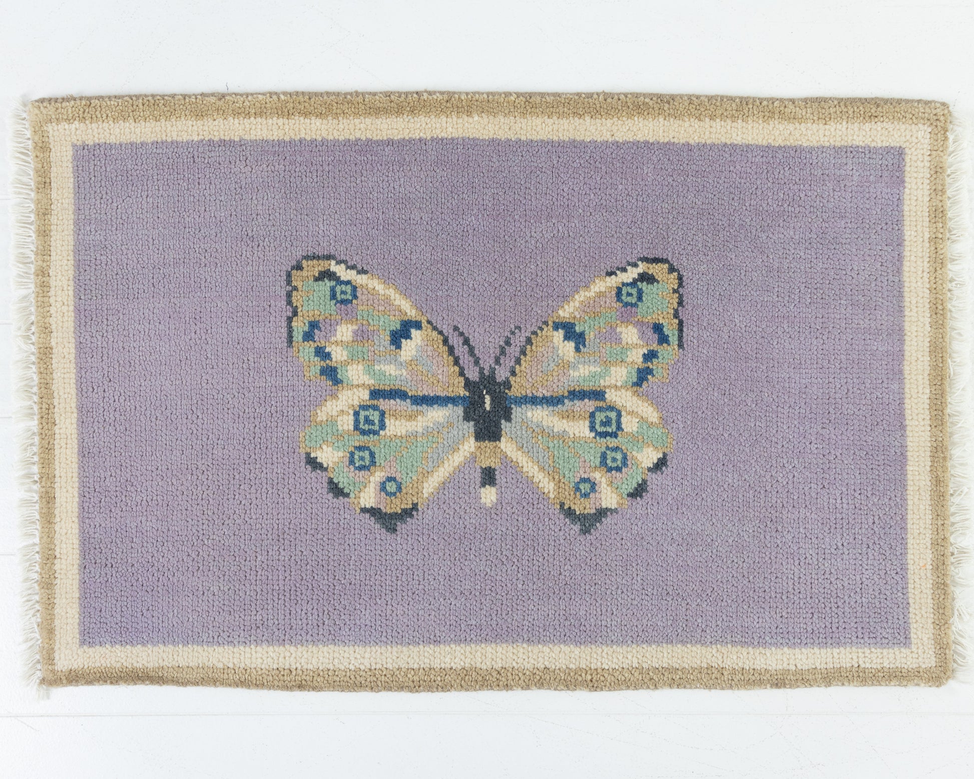 Hand-knotted wool rug featuring a butterfly motif on a lavender background with ivory and taupe border – Purple Butterfly Mini Rug by Locust Lane Rugs