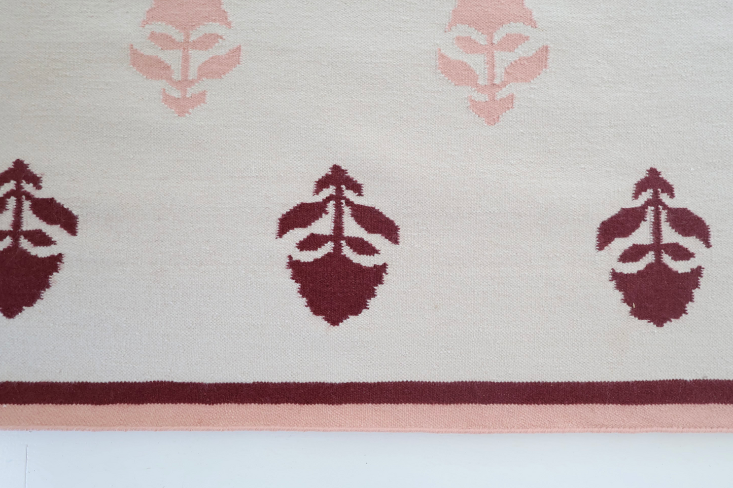 Flatweave rug with maroon and pink floral motifs and coordinating border, reversible construction — Cottage Floral Rug by Locust Lane Rugs