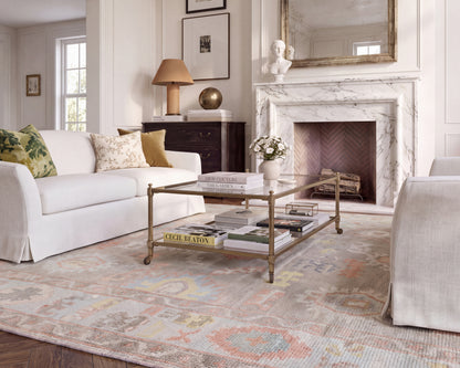 Sookie colorful floral Oushak area rug styled in a traditional living room with ivory sofas, a marble fireplace, and classic furnishings.