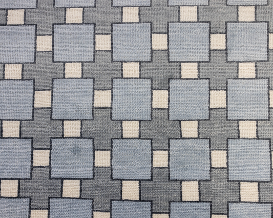 Patterned fabric with blue and beige squares on a gray background