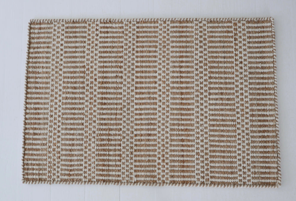 Textured brown and beige woven rug on a white background