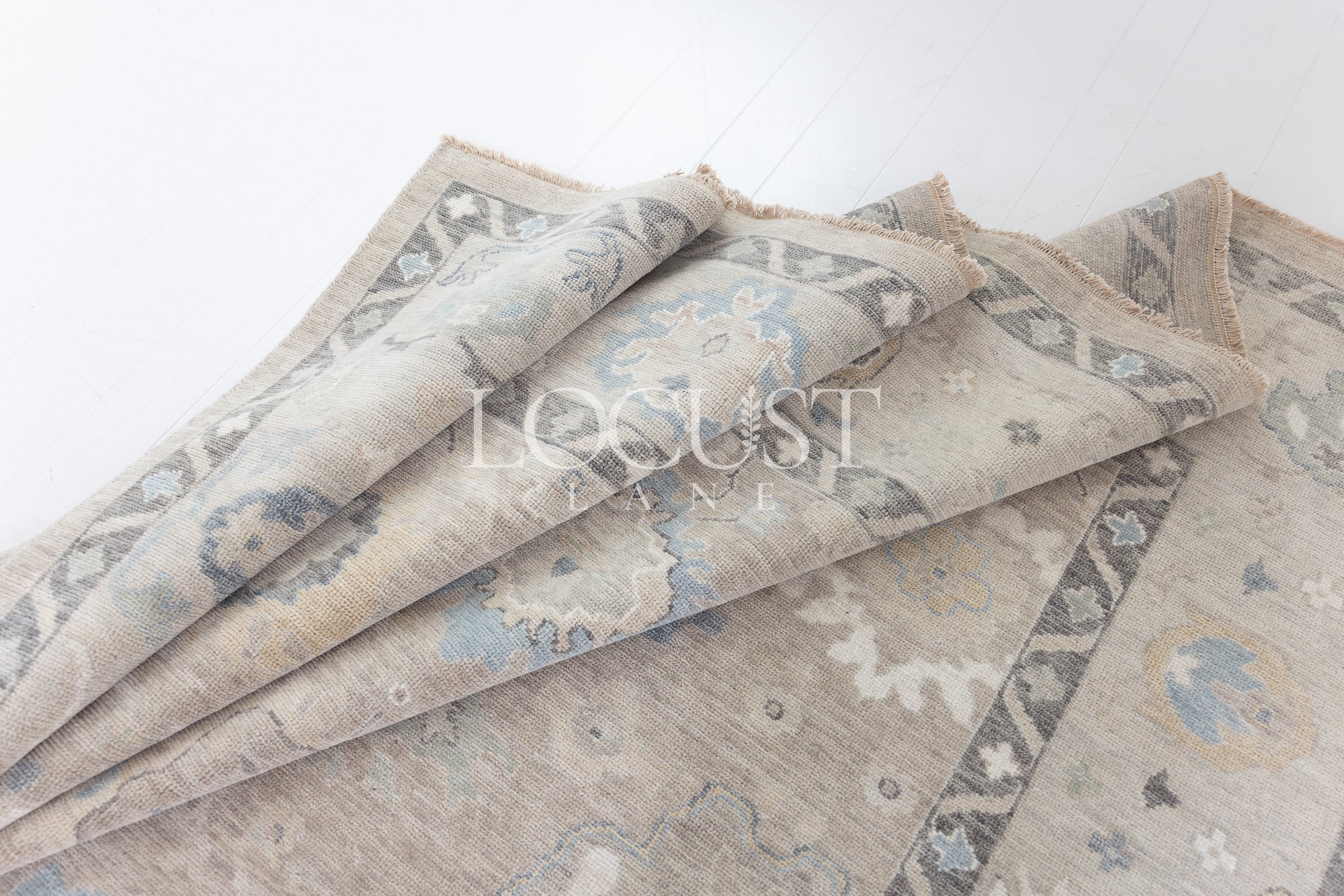 soft tones of beige, blue and grey hand knotted rug