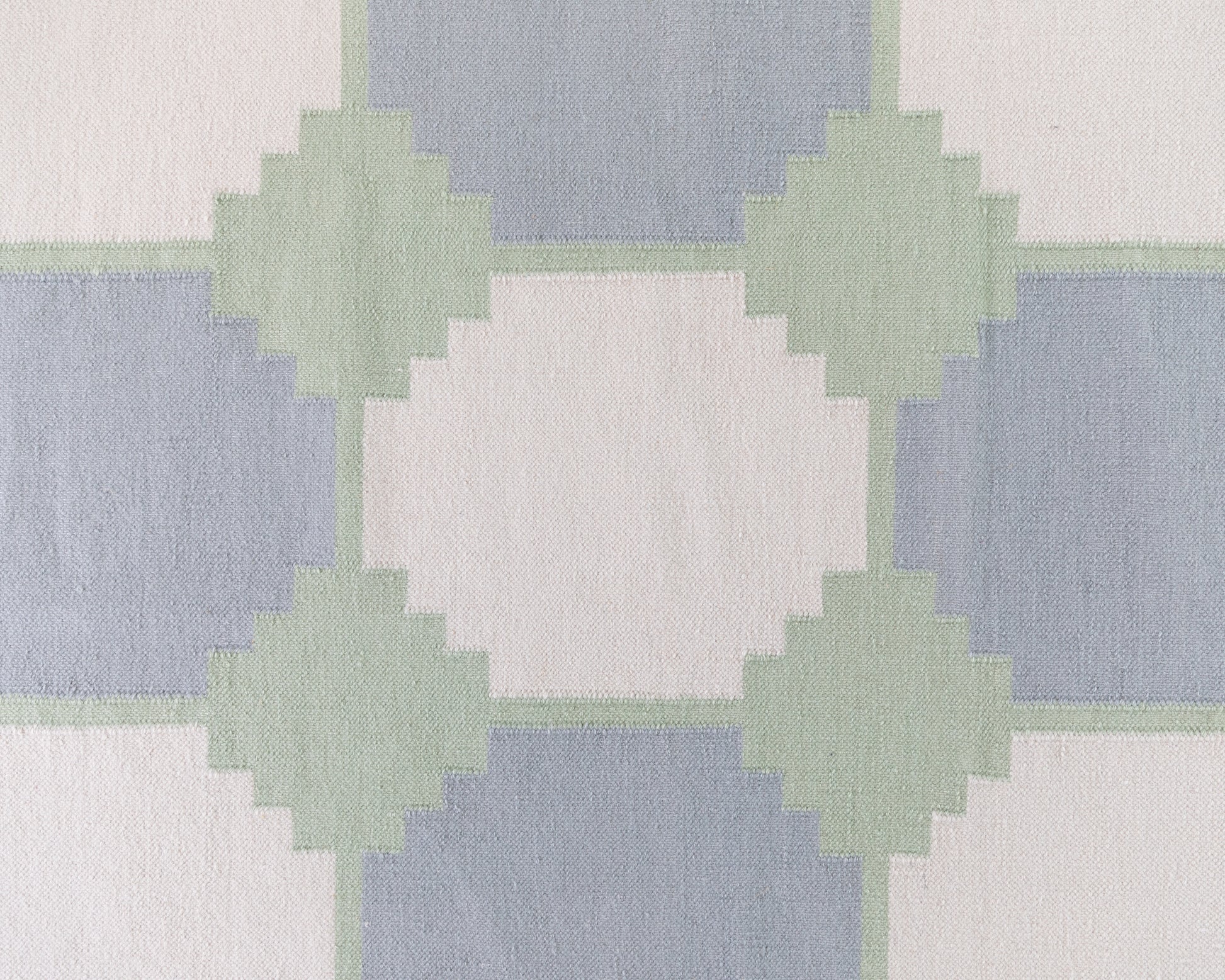 Close-up of the Geometric Flatweave Rug featuring oversized blue and sage geometric motifs on an ivory background.