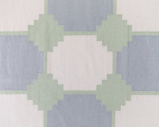Close-up of the Geometric Flatweave Rug featuring oversized blue and sage geometric motifs on an ivory background.
