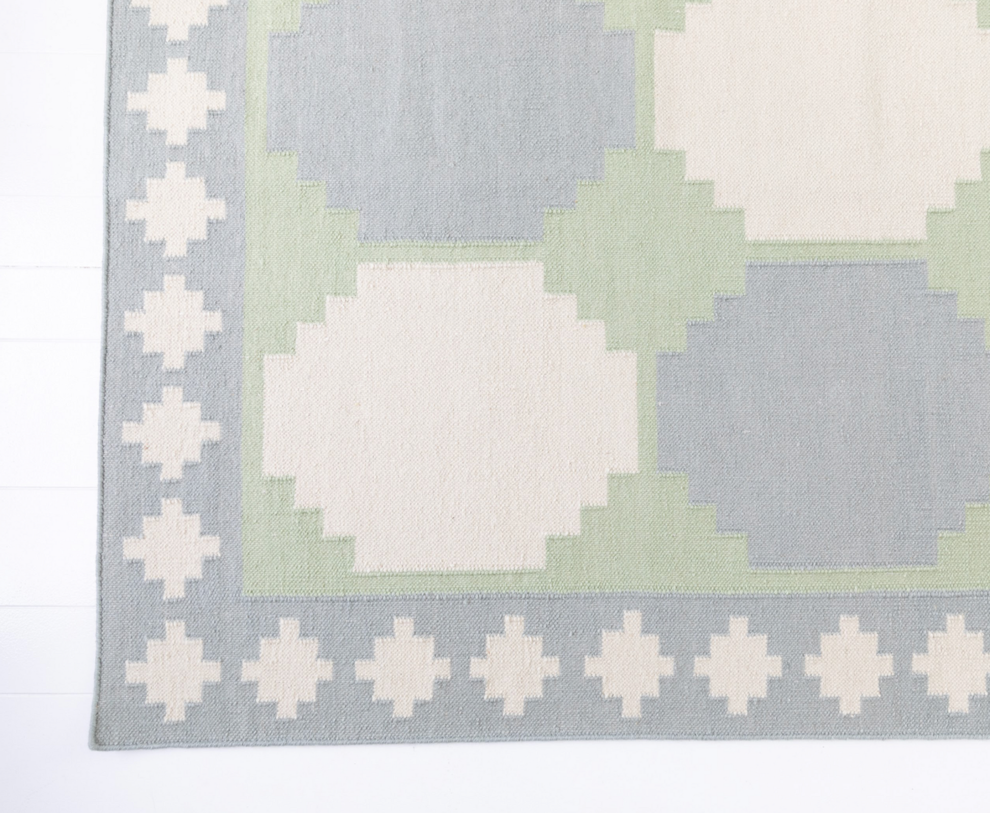 Angled view of the Geometric Flatweave Rug highlighting its handwoven wool texture and bold pattern.