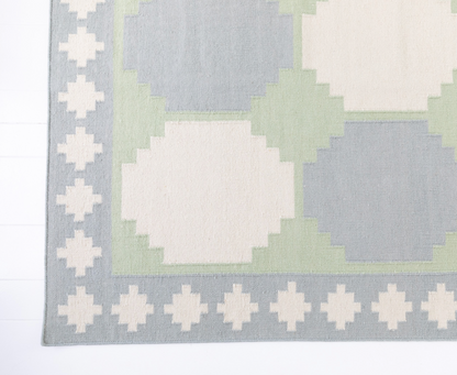 Angled view of the Geometric Flatweave Rug highlighting its handwoven wool texture and bold pattern.