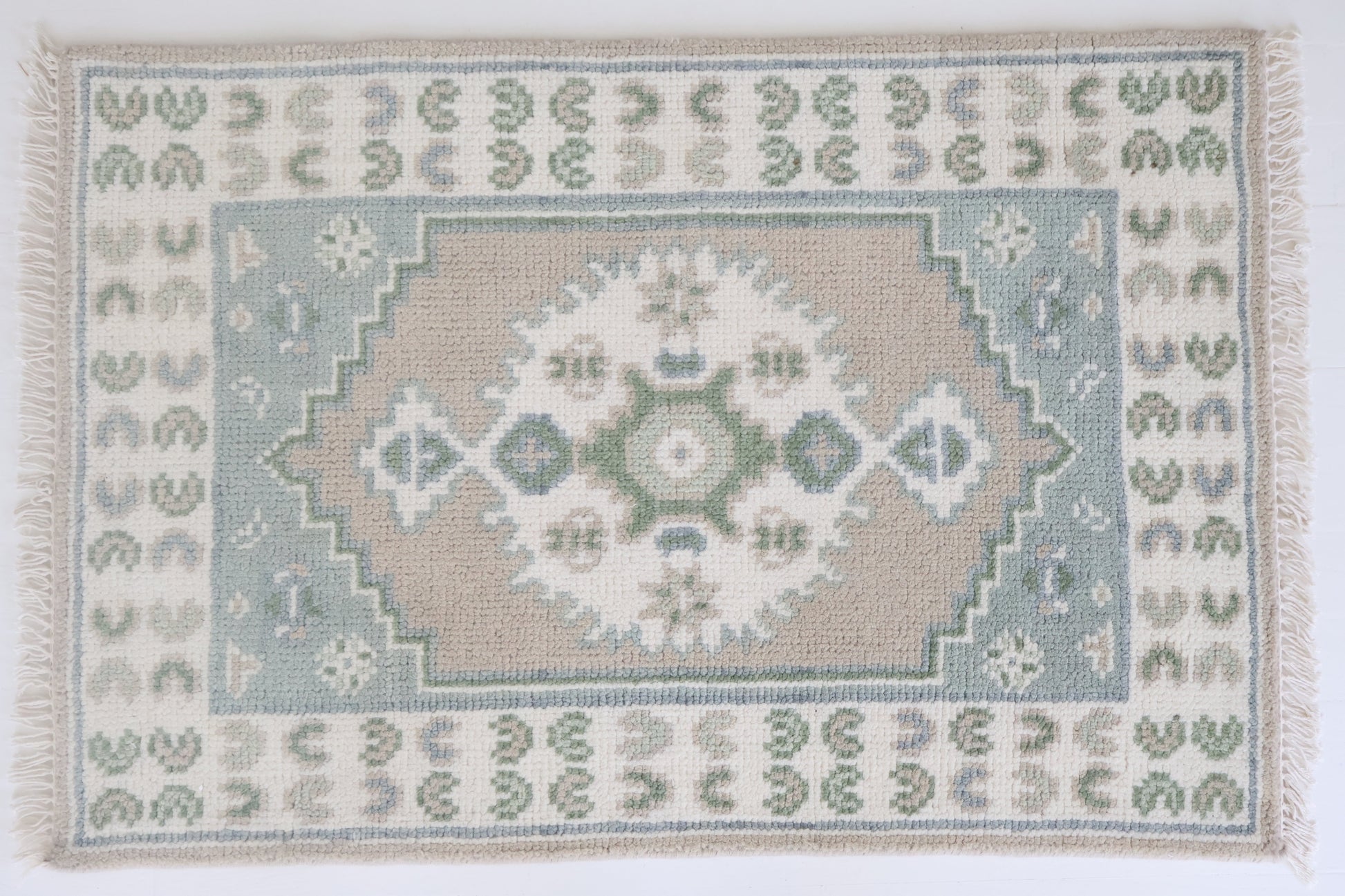 Hand-knotted wool rug with classic Oushak medallion in soft sage, sky blue, taupe, and ivory – Ivy Mini Rug by Locust Lane Rugs