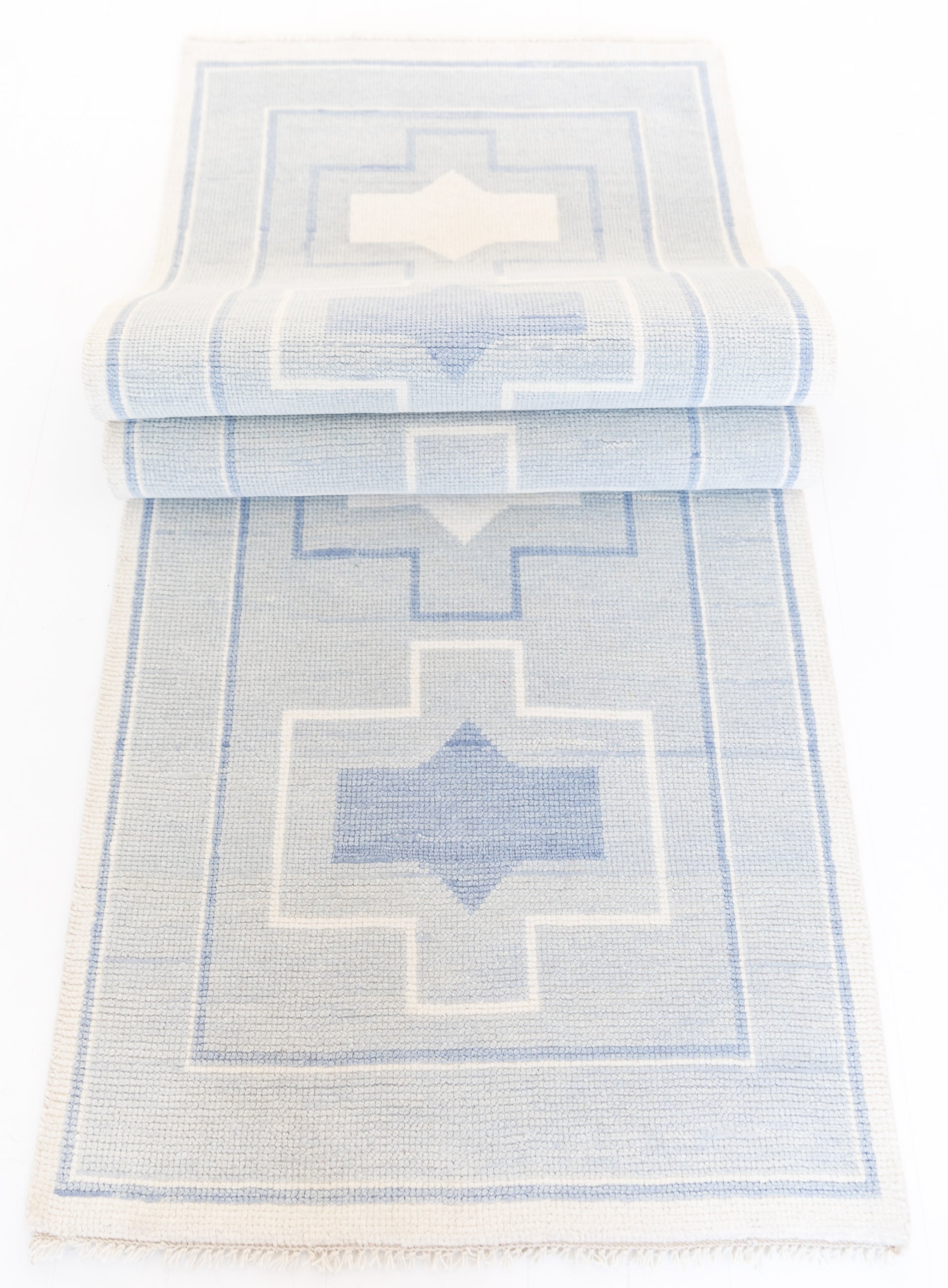 A blue and white geometric patterned runner rug.