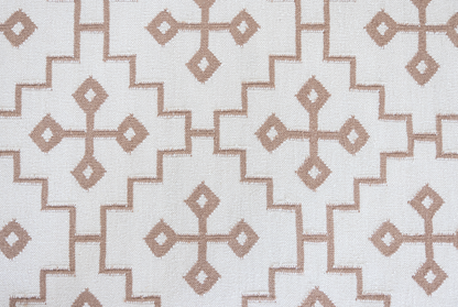 Orchid Geometric Flatweave Rug with a blush beige geometric pattern on a soft pink-beige background.
