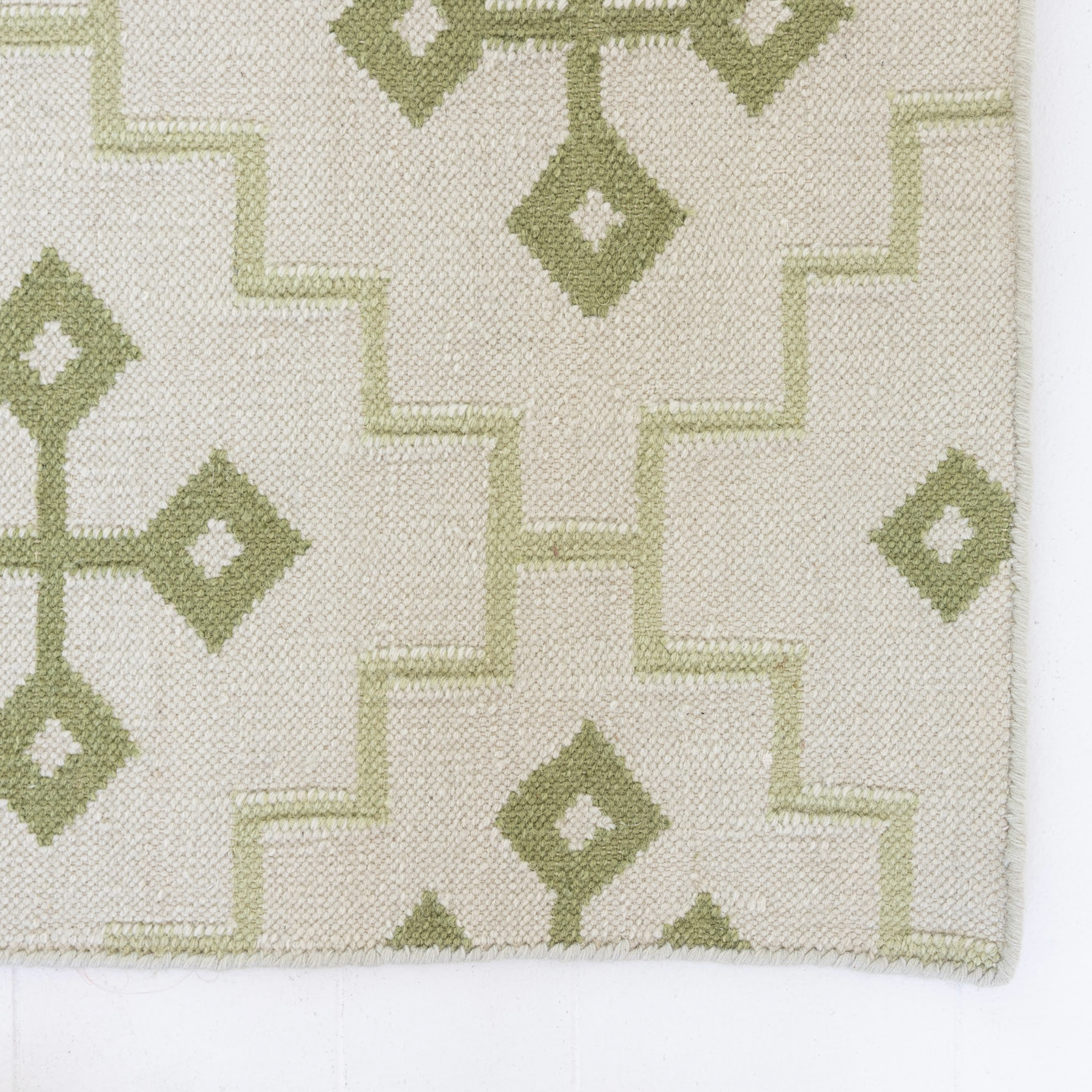 Close-up of the Pistachio Green Geometric Flatweave Rug highlighting its handwoven wool texture.