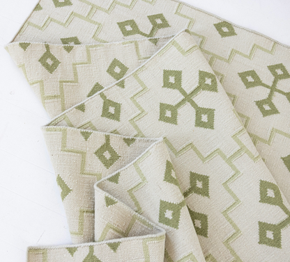 Folded Pistachio Green Geometric Flatweave Rug featuring its reversible handwoven construction.