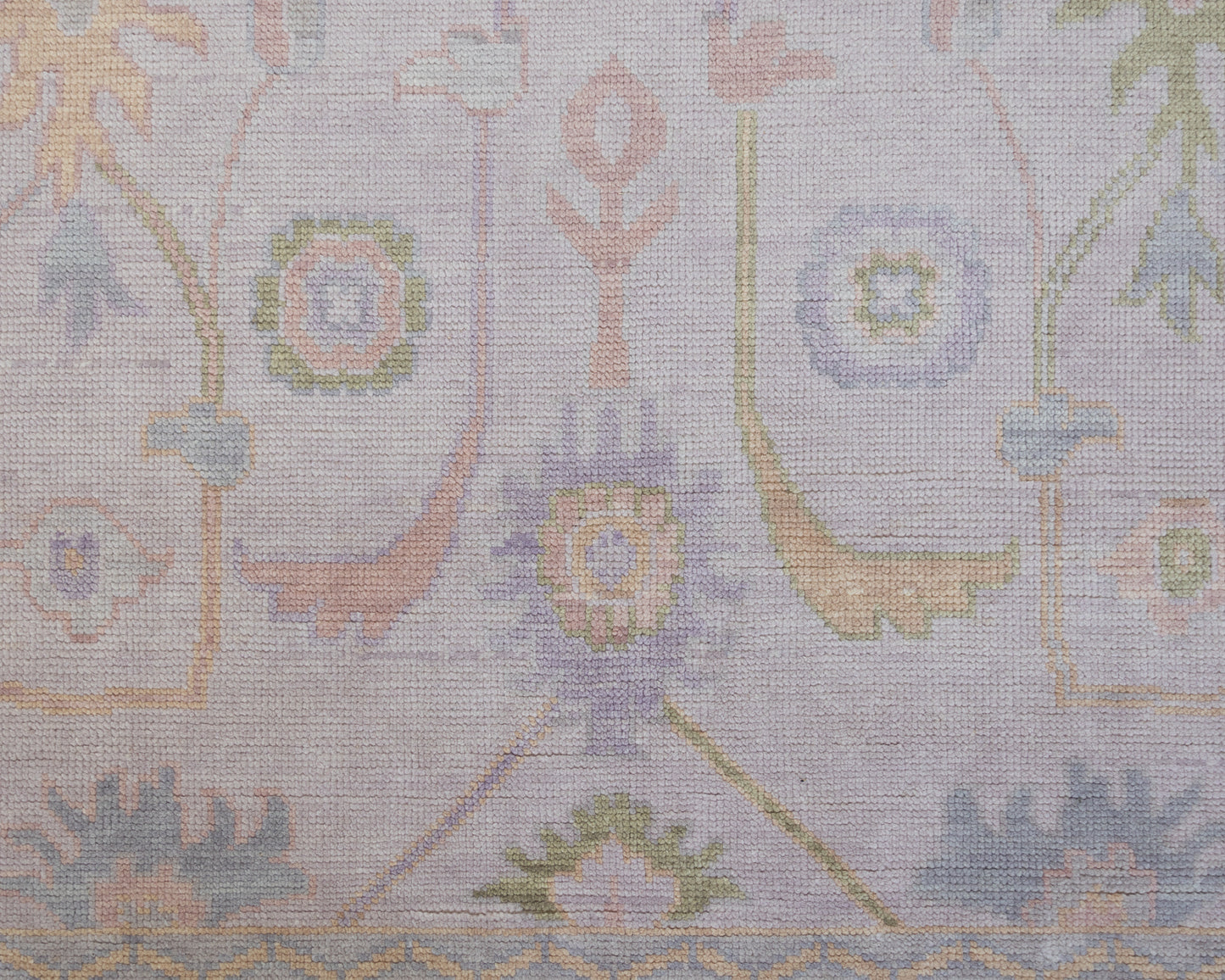 Hand-knotted wool rug in soft lavender and blush tones with sage and peach accents. The Rose Rug from Locust Lane features a delicate floral-inspired pattern that blends modern pastel hues with timeless craftsmanship.