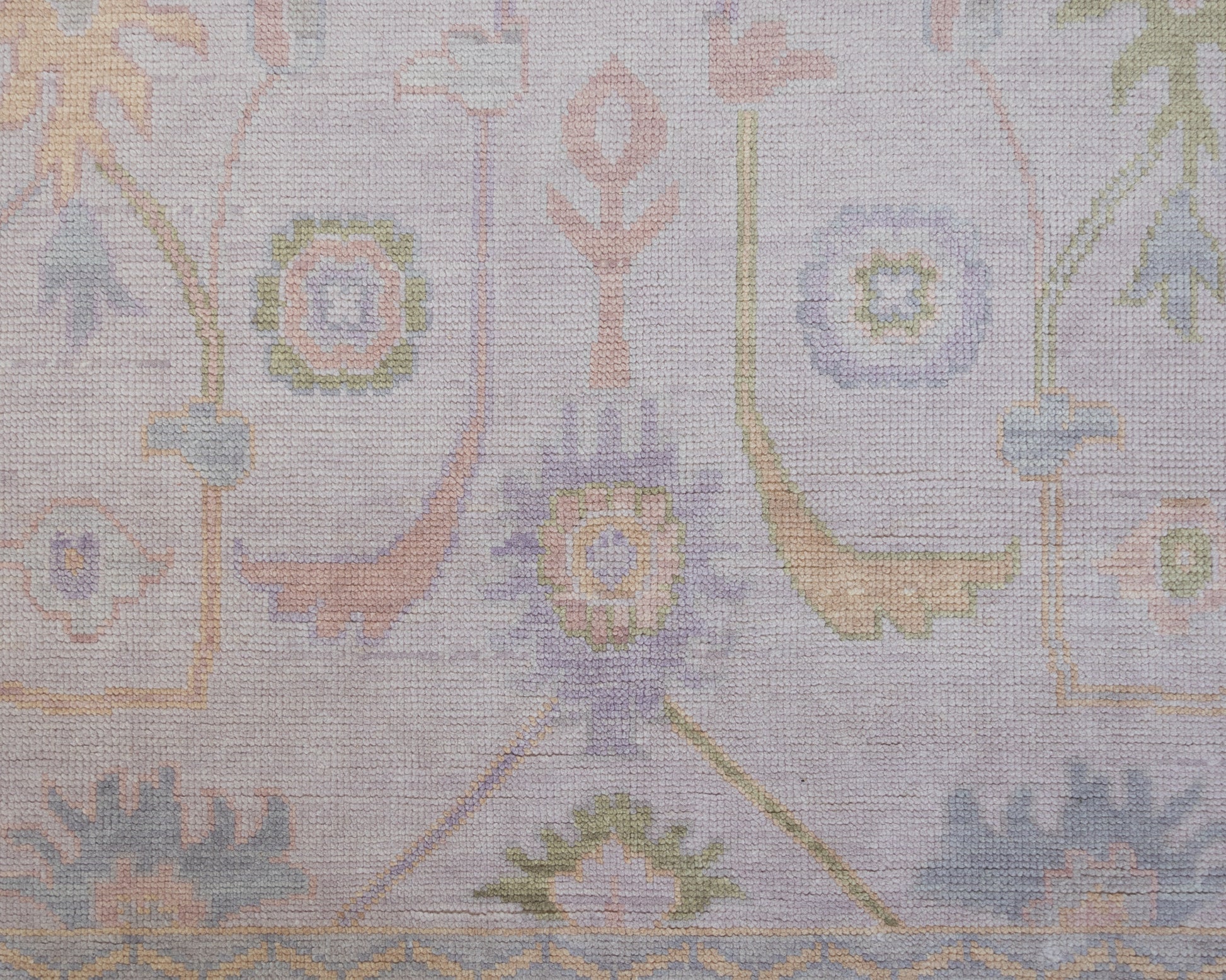 Hand-knotted wool rug in soft lavender and blush tones with sage and peach accents. The Rose Rug from Locust Lane features a delicate floral-inspired pattern that blends modern pastel hues with timeless craftsmanship.