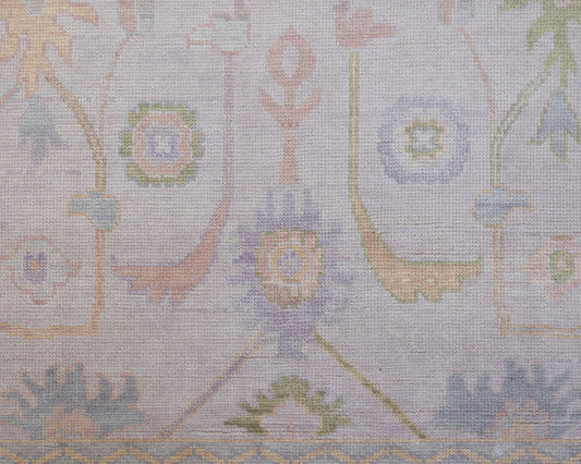 Hand-knotted wool rug in soft lavender and blush tones with sage and peach accents. The Rose Rug from Locust Lane features a delicate floral-inspired pattern that blends modern pastel hues with timeless craftsmanship.