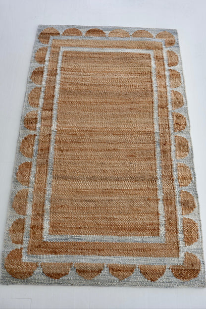 Handwoven jute and wool rug in natural tones with a stone-blue scalloped border – Stone Blue Scalloped Edge Rug by Locust Lane Rugs