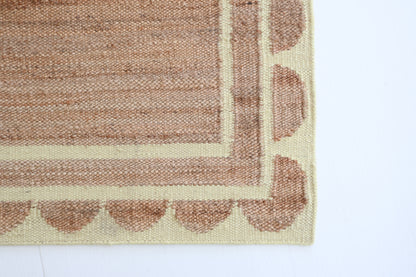 Handwoven jute and wool rug in natural tones with a pear-green scalloped border – Sweet Pear Scalloped Edge Rug by Locust Lane Rugs