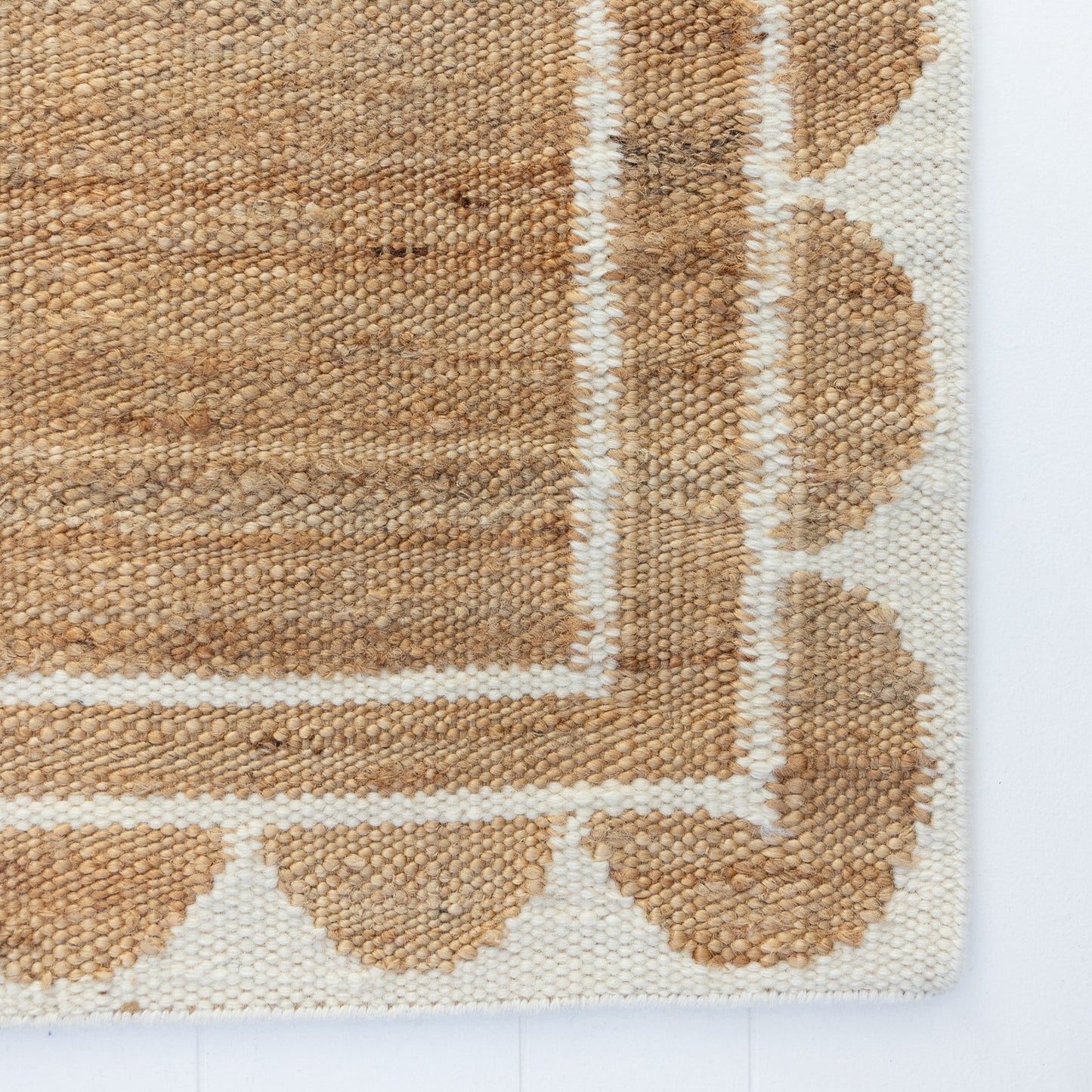 Handwoven jute and wool rug in natural tones with a crisp white scalloped border – White Scalloped Edge Rug by Locust Lane Rugs