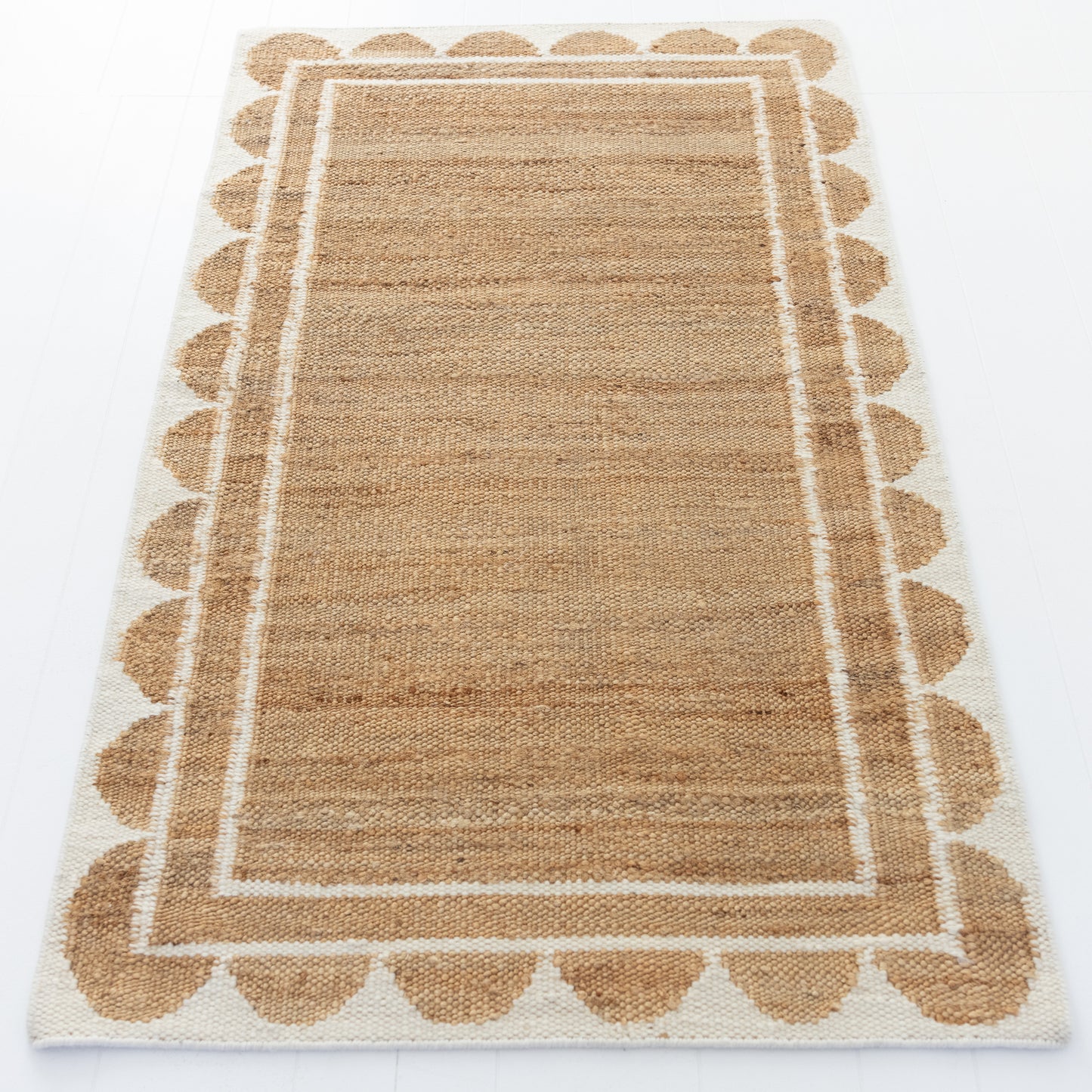 Handwoven jute and wool rug in natural tones with a crisp white scalloped border – White Scalloped Edge Rug by Locust Lane Rugs
