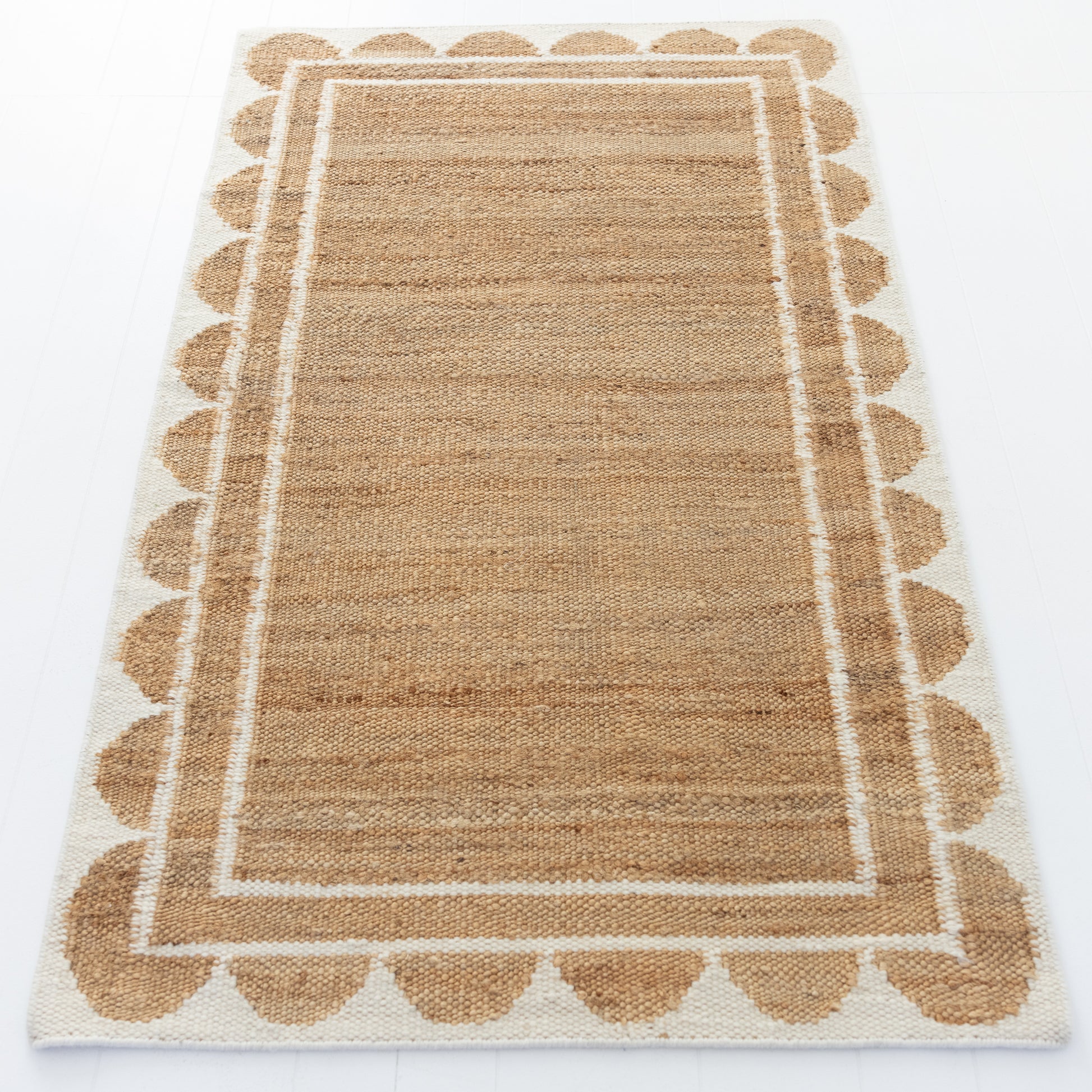 Handwoven jute and wool rug in natural tones with a crisp white scalloped border – White Scalloped Edge Rug by Locust Lane Rugs